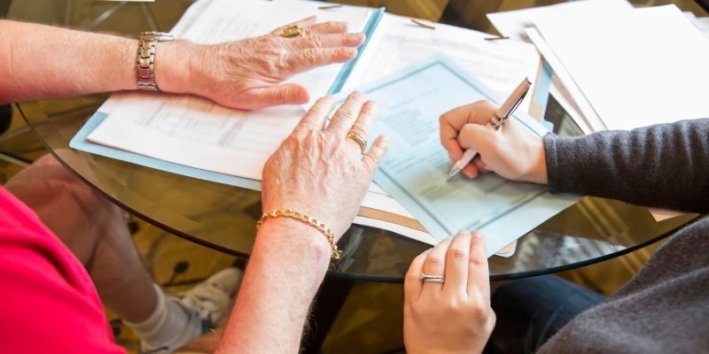 une personne entrain de signer un document