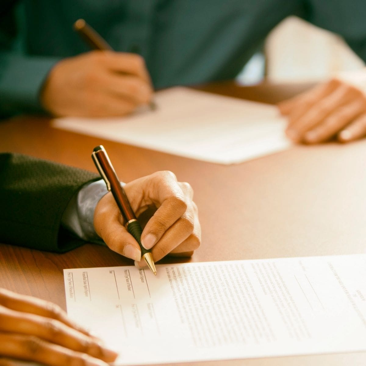 2 personnes entrain de signer des documents